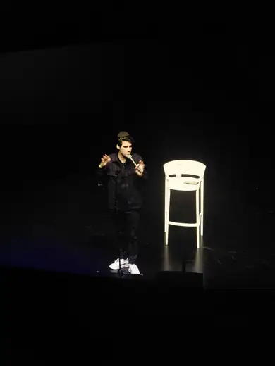 Dovi Neuburger performing on a dark stage