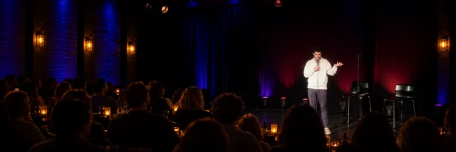 Dovi Neuburger performing in an AI-extended comedy club scene