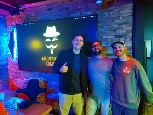 Comedians in front of the Anonymous Comedy backdrop