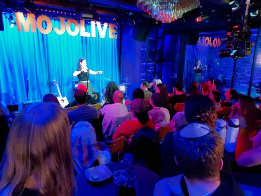 Comedians hugging on the MOJO Live stage